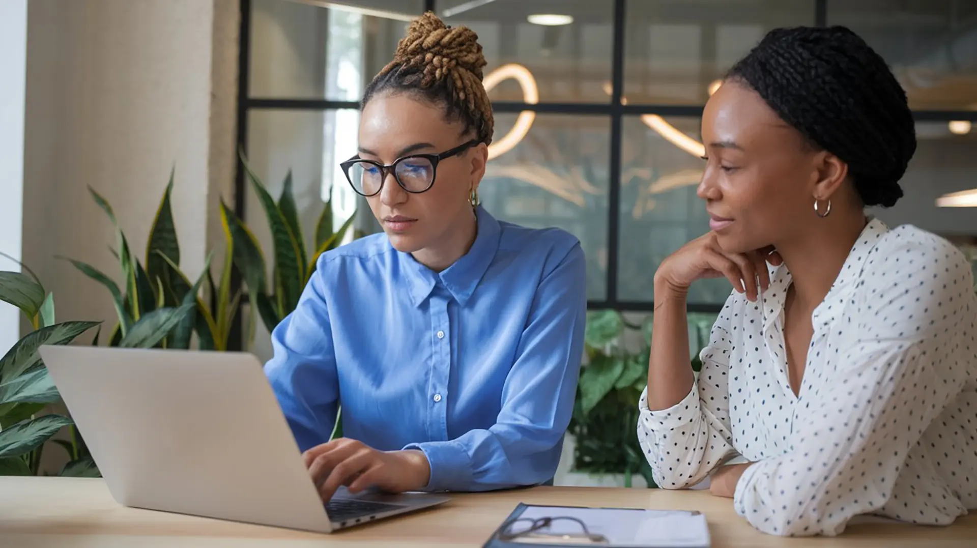 Due professioniste che analizzano il portfolio di Penny Black Agency su un laptop